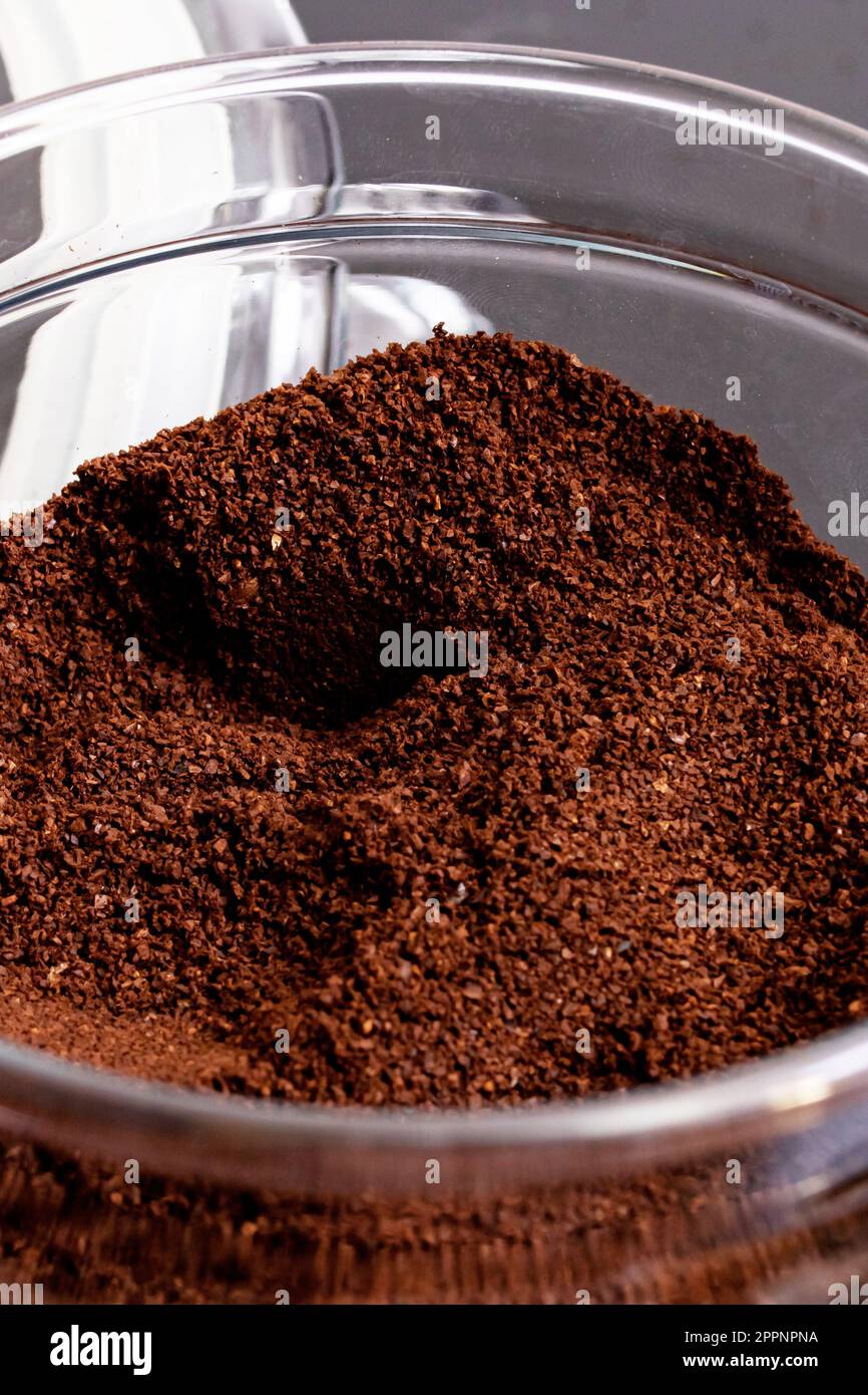 Gemahlener Kaffee in einem Glas auf dem schwarzen Holztisch Stockfoto