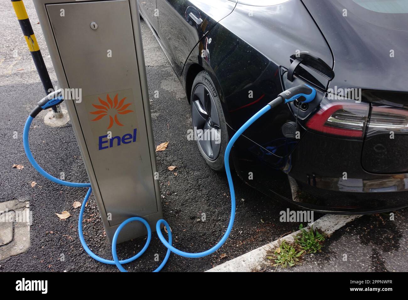 Ein Elektroauto im Wert von 100 $ wird auf der Straße in einer kostenlosen Ladestation von Enel in Italien aufgeladen. Stockfoto