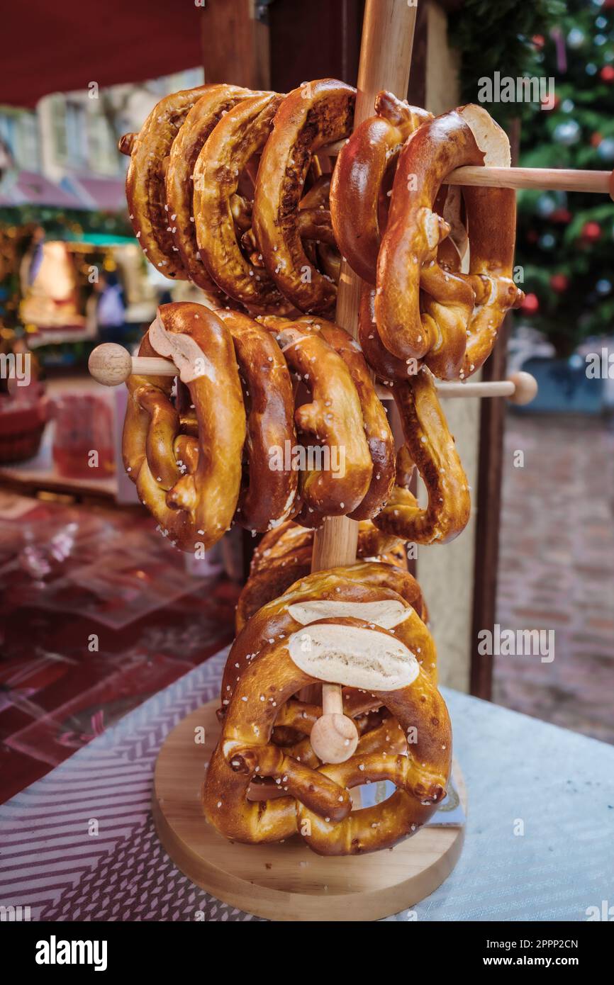 Brezel oder Brezel ist eine Art gebackenes Gebäck aus Teig, der in der Regel zu einem Knoten geformt wird. Brezeln auf einem Holzständer in einem französischen Restaurant Stockfoto