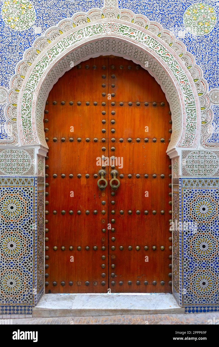 Fes, Marokko atemberaubende handbemalte Tür einer alten Moschee mit handgeschnitztem Putz. Stockfoto