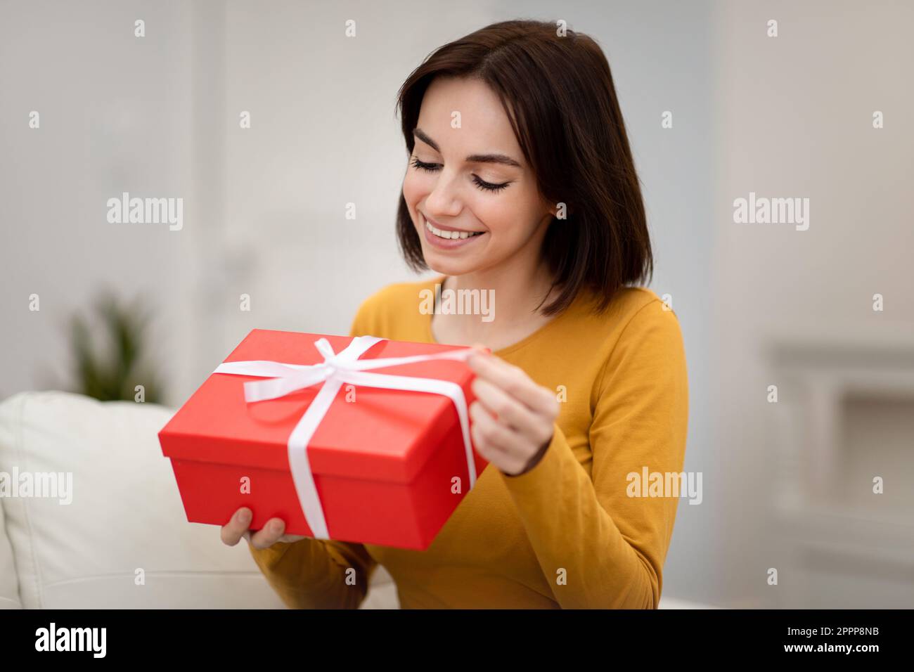 Nahaufnahme einer schönen jungen Frau mit roter Geschenkbox Stockfoto