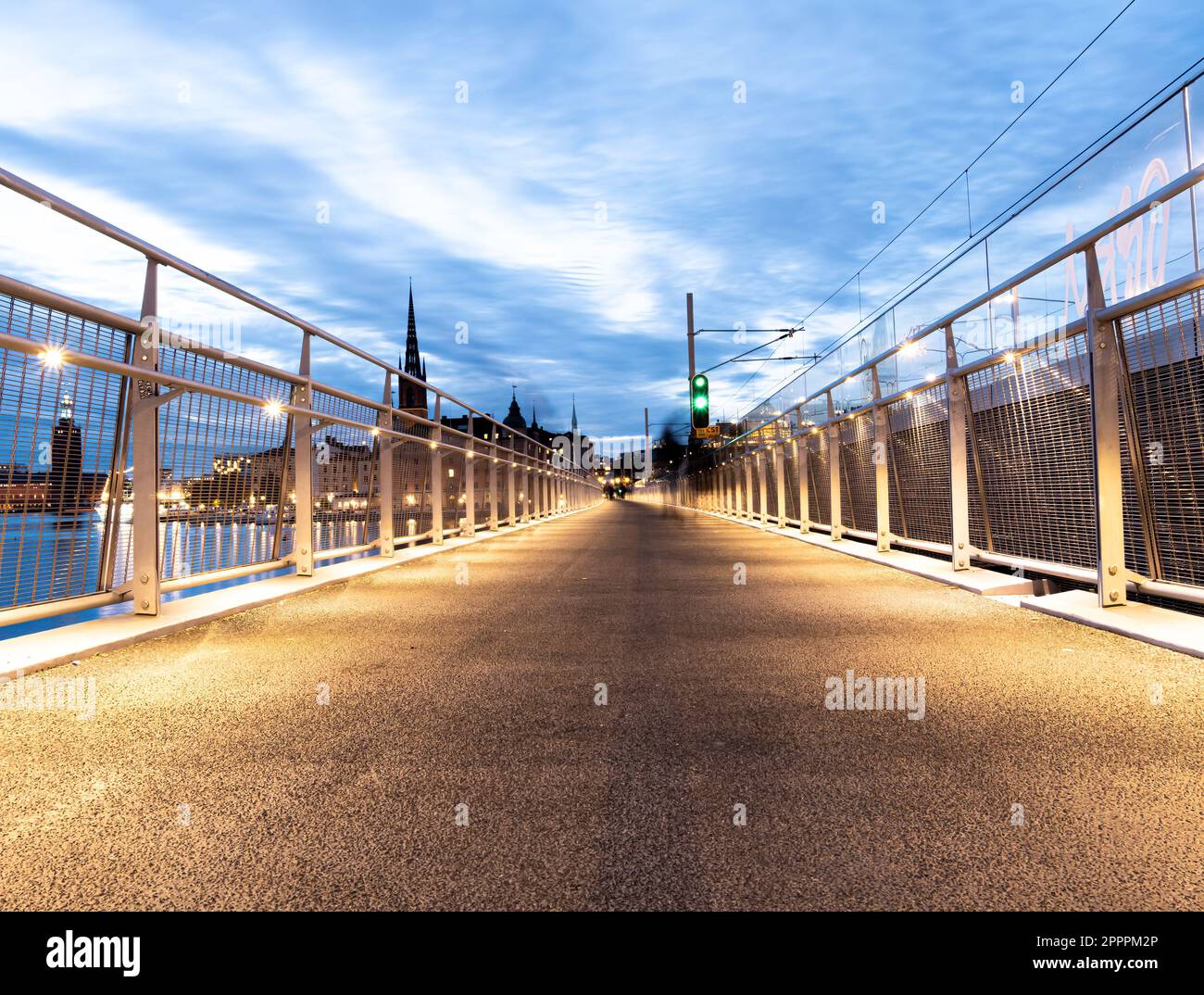 Stockholm, Schweden - 4. Oktober 2022: Eine lange, gewundene Brücke, die sich über ein Stadtbild in Richtung einer Insel am Himmel erstreckt, bietet den Weg nach vorne für tr Stockfoto