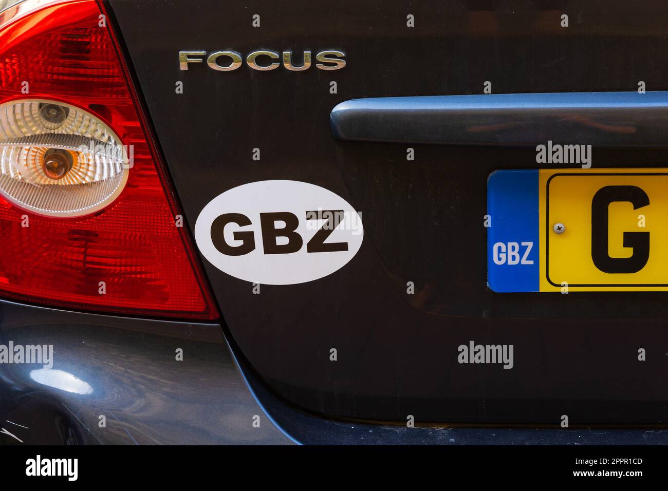 Ländercode-Aufkleber und Nummernschild auf der Rückseite eines Ford Focus Wagens. Das britische Überseegebiet Gibraltar, der Felsen von Gi Stockfoto