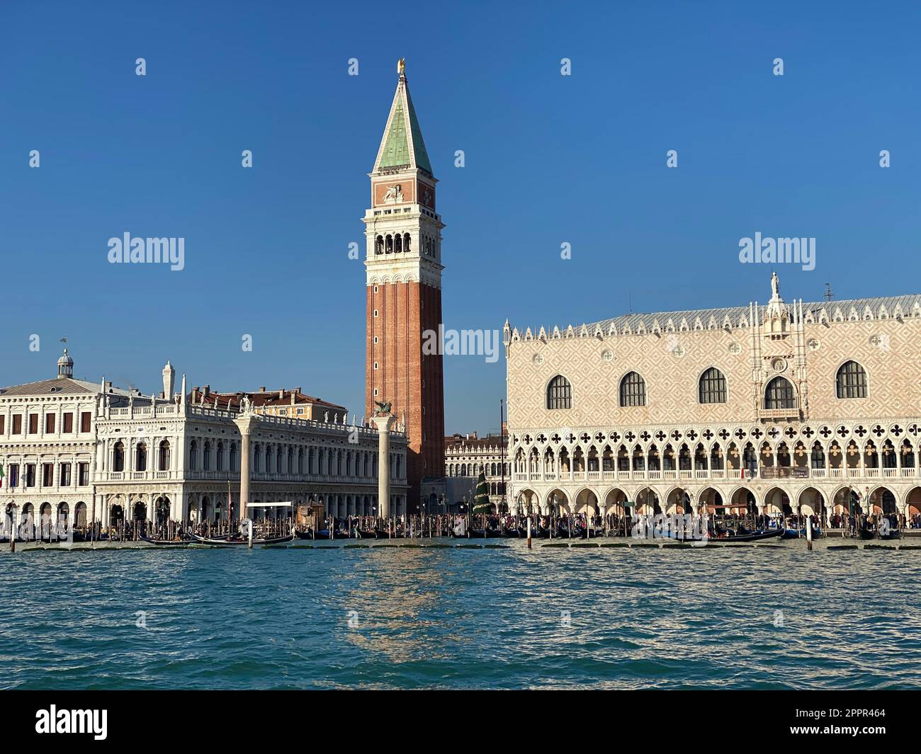 Ein beeindruckendes Hochhaus steht hoch über dem Stadtbild, mit seiner Reflexion im Wasser darunter Stockfoto