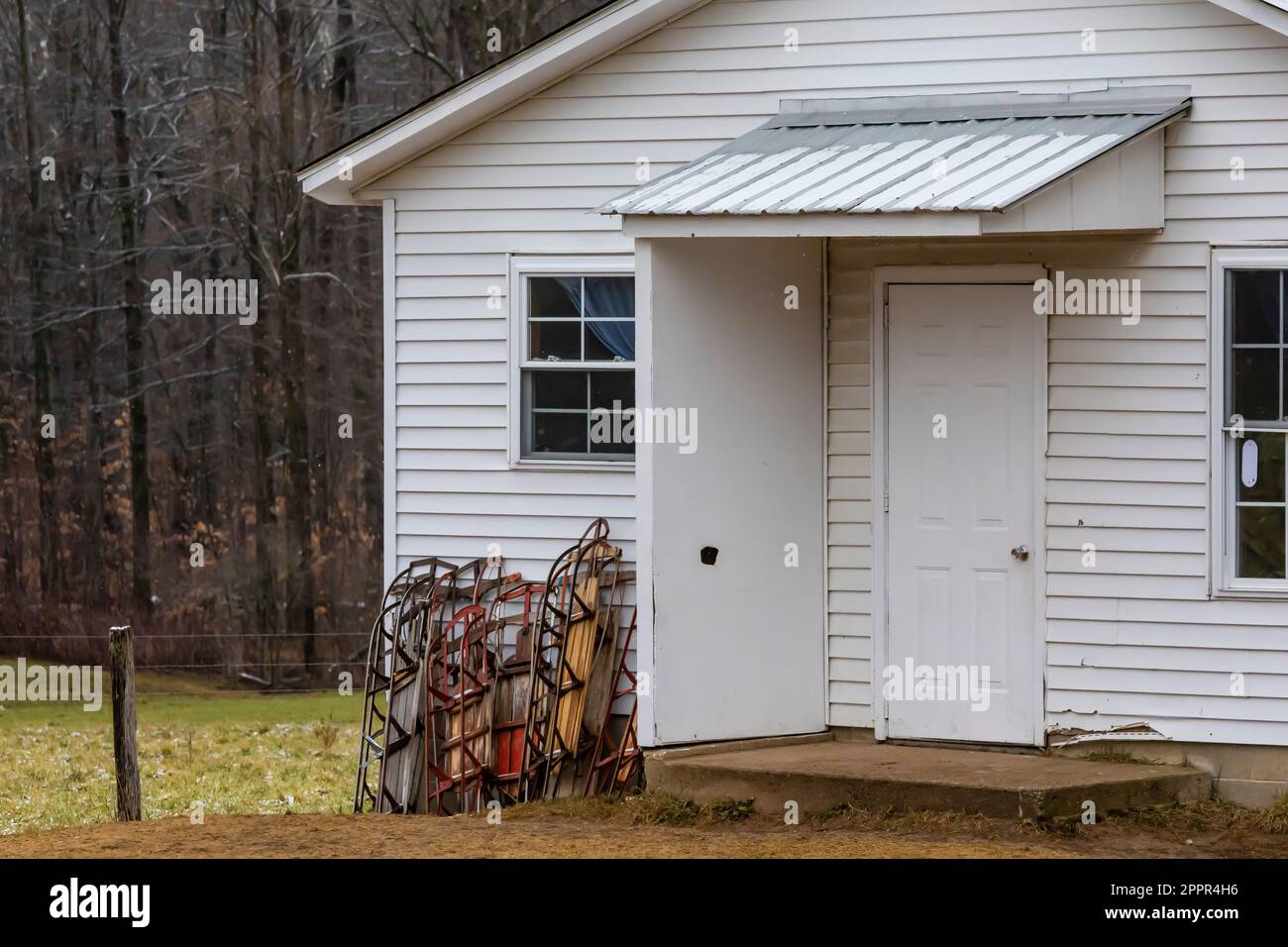 Ein-Zimmer-Schule mit Schneeschlitten draußen, in einer Amish-Gemeinde in Zentral-Michigan, USA [Keine Immobilienfreigabe; nur redaktionelle Lizenzierung] Stockfoto