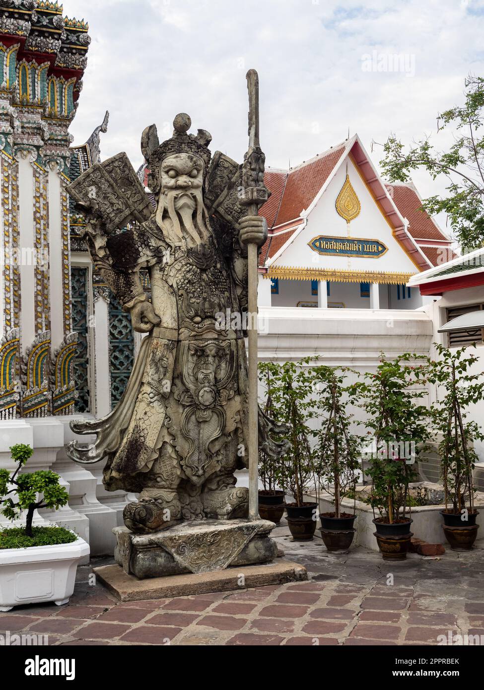 Eine historische chinesische Kriegerstatue aus Stein, die sich im ruhigen buddhistischen Tempel Wat Pho im belebten Bangkok, Thailand, befindet. Die alte Handwerksmannshi Stockfoto