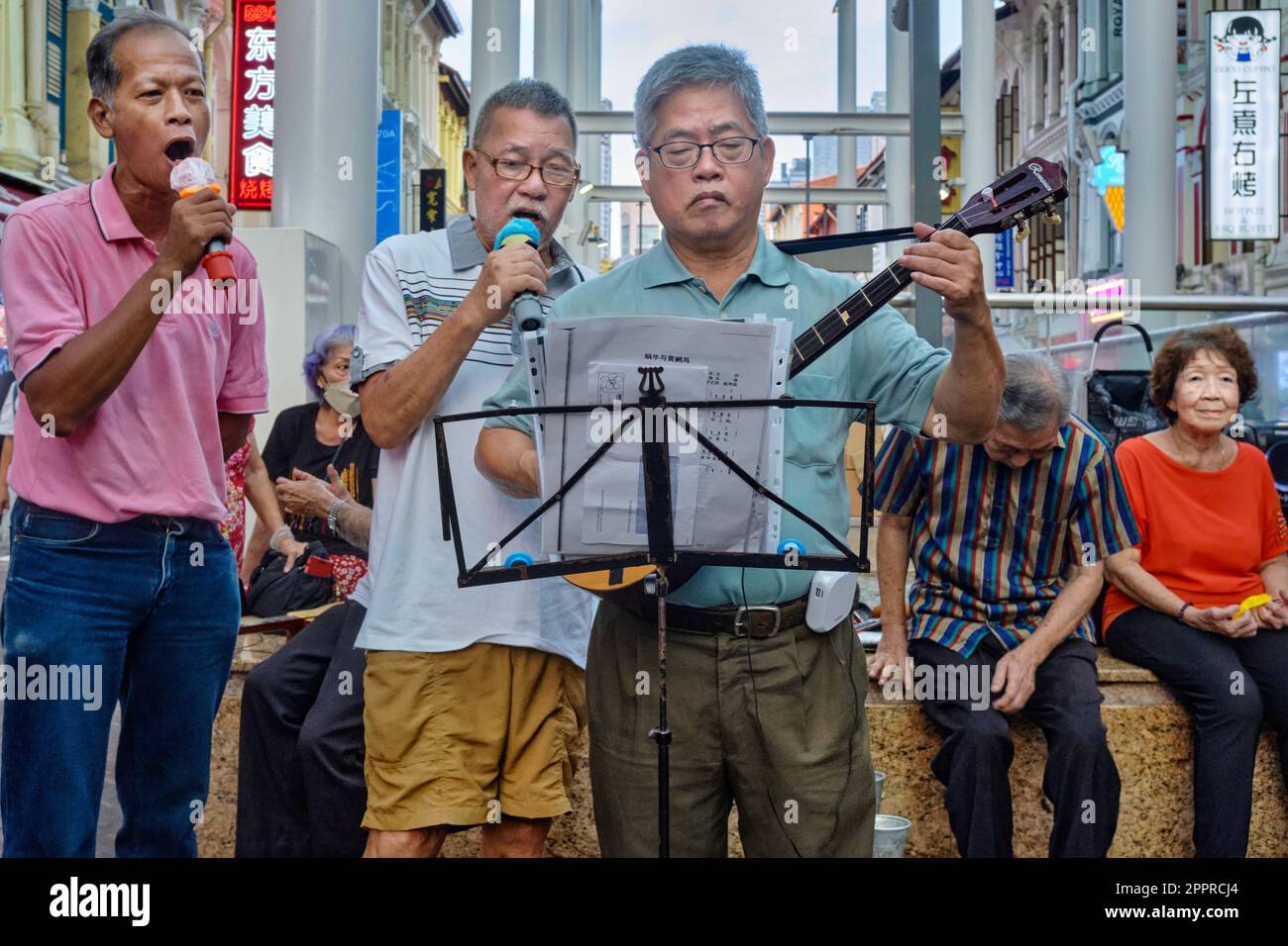 Drei Singapur-Rentner, ein chinesischer Lautenspieler und zwei chinesische Sänger spielen traditionelle chinesische Lieder: Chinatown, Singapur Stockfoto