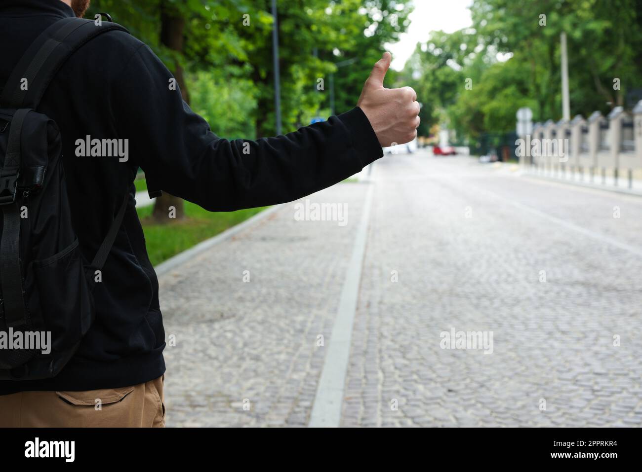 Ein Mann, der sich auf der Straße ein Auto schnappt, Nahaufnahme. Anhalter-Tour Stockfoto