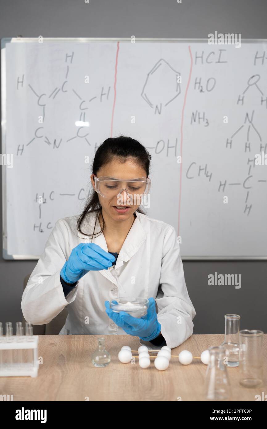 Glückliche Frau, die Experimente im Labor macht. Wissenschafts- und Bildungskonzept. Stockfoto