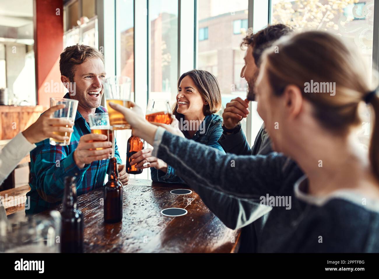 Ein Bier mit Freunden an der Bar. Eine Gruppe von Freunden, die einen Toast aussprechen und sich