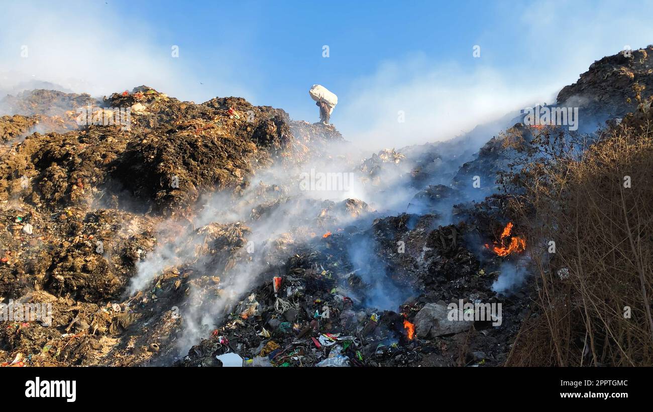 Toxischer Rauch auf Deponien: Sanitäter sortieren Müll unter Umweltgefahren Stockfoto