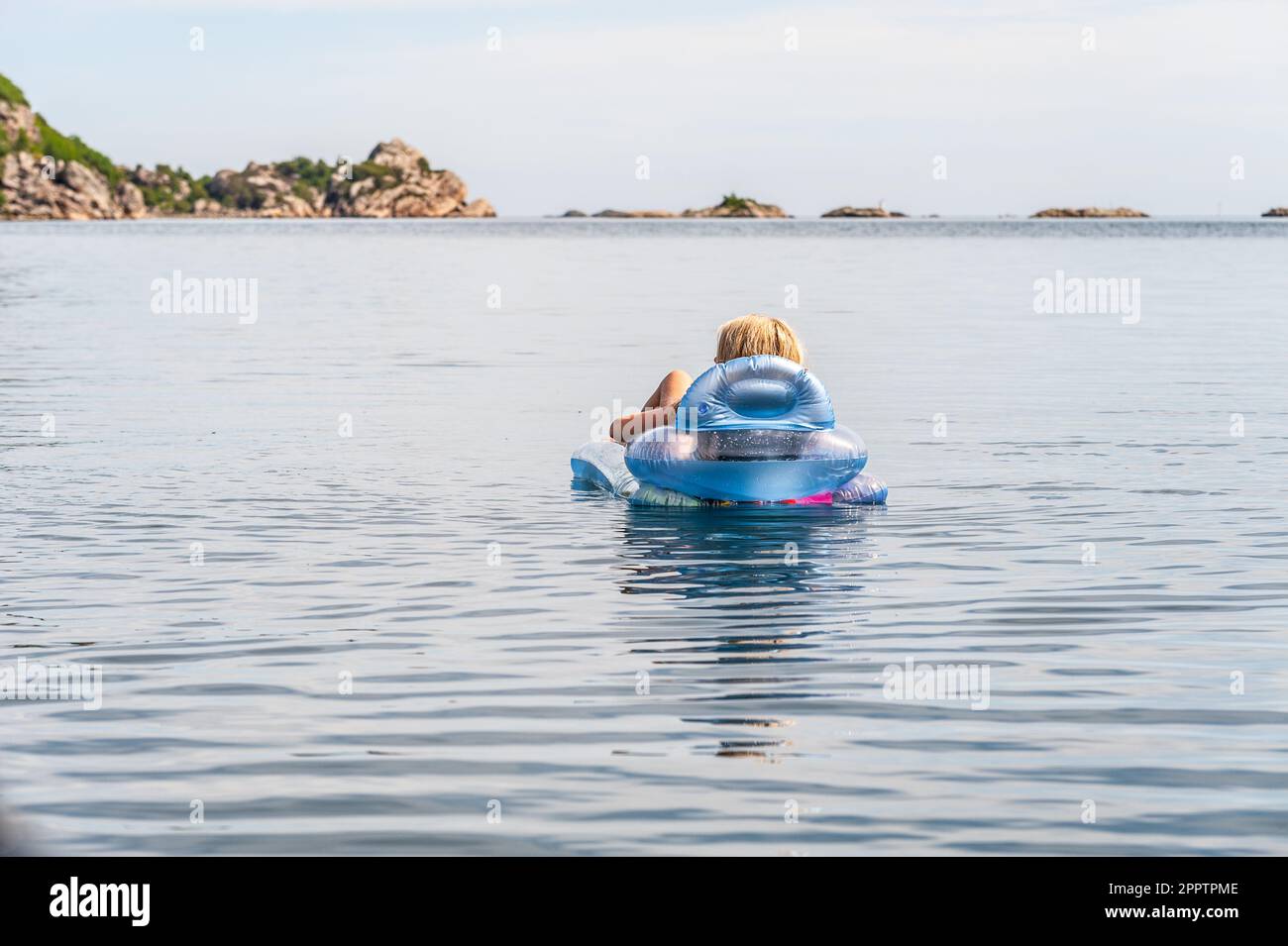 Person, die auf einer aufblasbaren Matratze auf See ruht Stockfoto