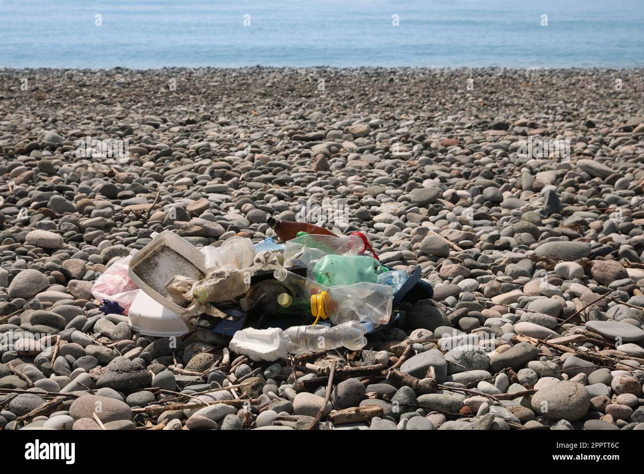Müllhaufen am Kieselstrand in der Nähe des Meeres. Umweltverschmutzungskonzept Stockfoto