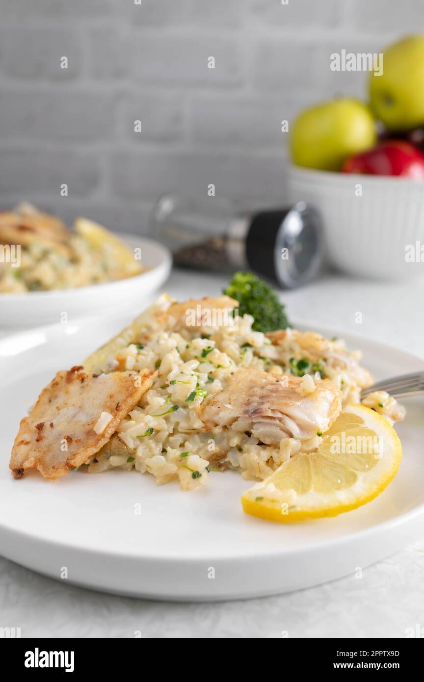 Fisch mit Brokkoli und braunem Reis auf einem Teller. Gesunde Ernährung oder Fitness-Mahlzeit Stockfoto