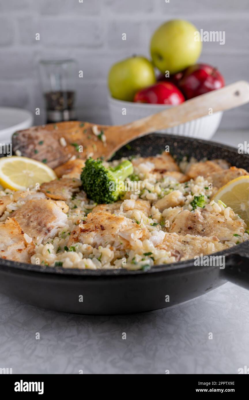 Fischpfanne mit braunem Reis, Brokkoli und Porree Stockfoto