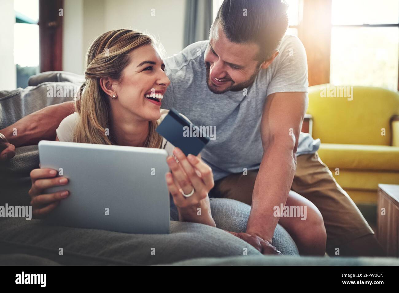 Babe ist glücklich, solange es keine langen Warteschlangen gibt. Ein junges Paar, das auf einem Tablet online einkauft. Stockfoto