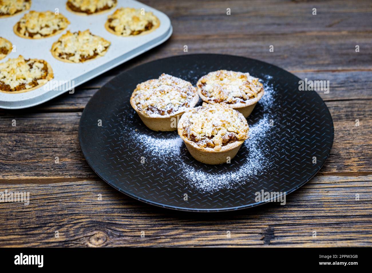 Hausgemachte Apfelkuchen, kleine Apfelkuchen auf rustikalem Holzhintergrund, Nahaufnahme. Stockfoto