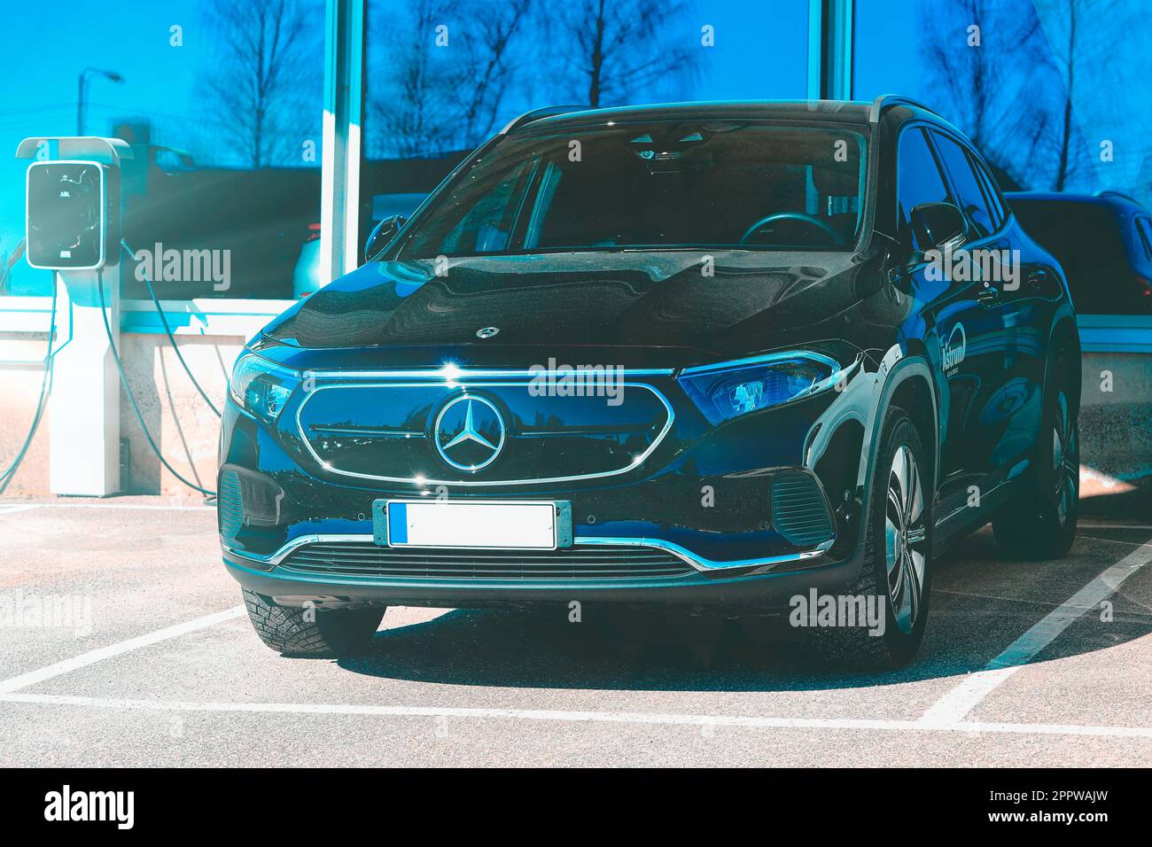 Schwarzer Elektro-SUV Mercedes-Benz EQA 250 mit Akku, Jahr 2023, mit DEFA EV-Ladegerät mit Blautönung. Salo, Finnland. 10. April 2023. Stockfoto