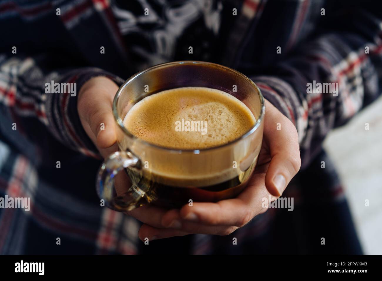 Nahaufnahme einer Person, die eine Tasse schwarzen Kaffee hält Stockfoto