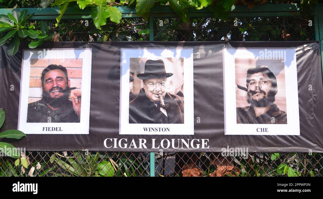 Auf einem Banner, das für die Cigar Lounge Werbung macht, werden Fidel Castro, Winston Churchill und Che Guevara, die in Jomtien, Pattaya, Thailand, Zigarren rauchen, aufgeführt. Stockfoto