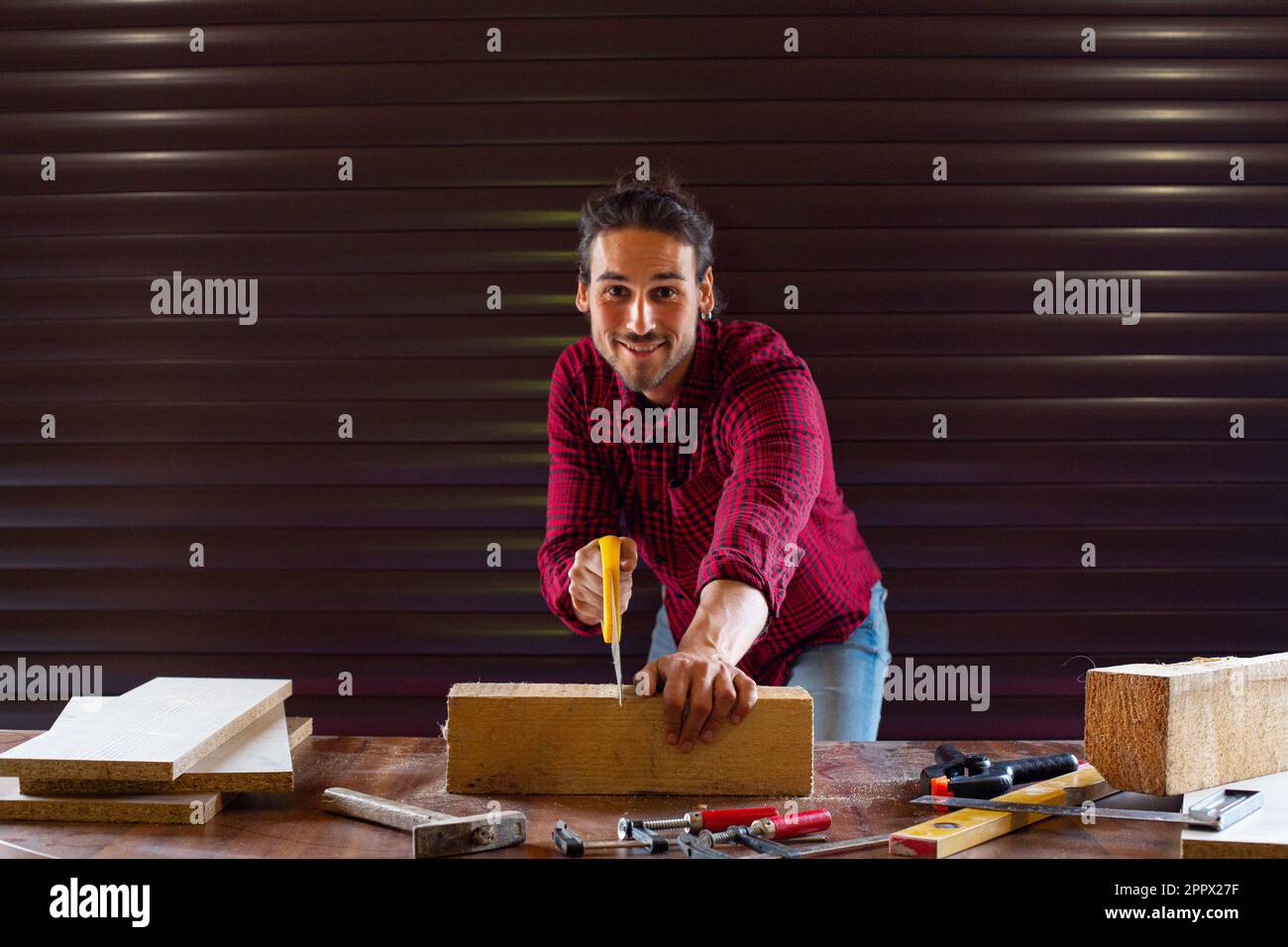 Gut aussehender Mann, der in der Garage arbeitet Stockfoto