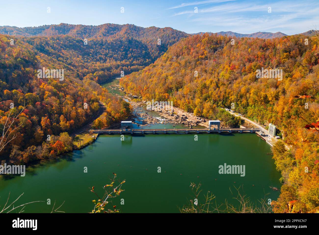 Ein weitläufiger See, umgeben von einer üppigen, grünen Landschaft mit Bäumen, auf einem malerischen Hügel gelegen Stockfoto