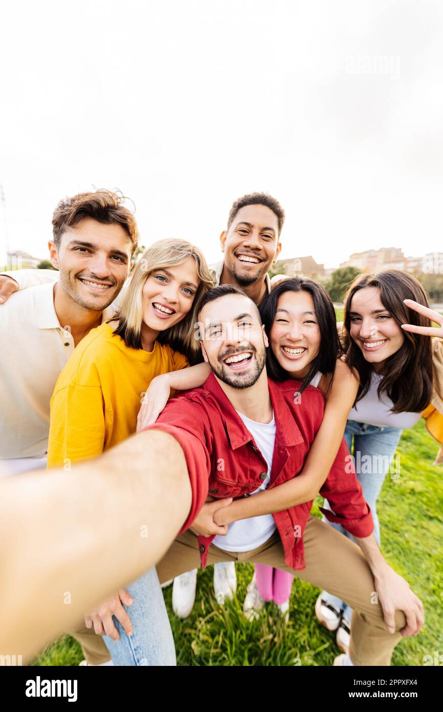 Vertikales Gruppenporträt von multiethnischen jungen Freunden, die Selfie mit dem Handy machen Stockfoto