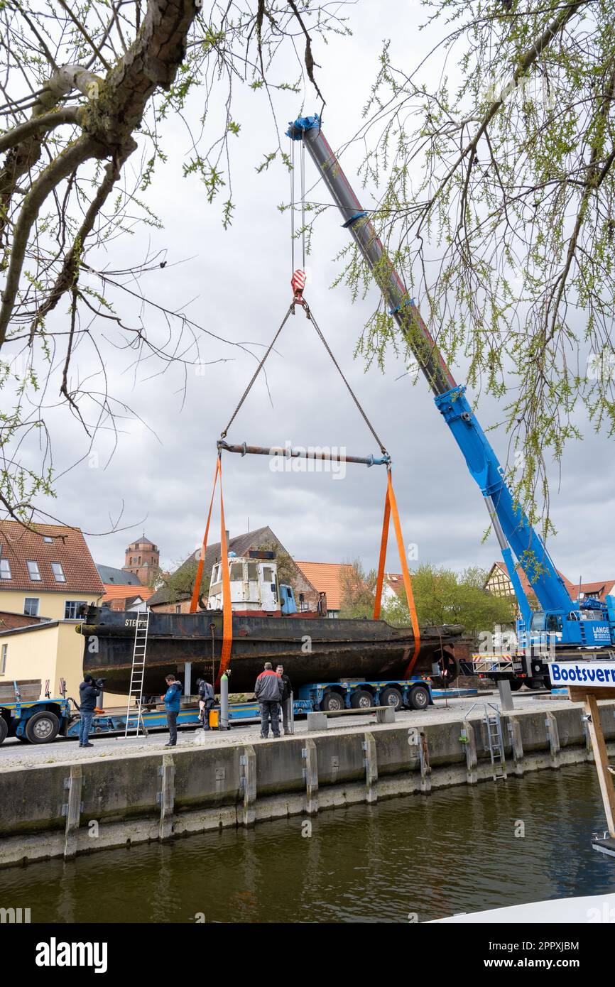 25. April 2023, Mecklenburg-Vorpommern, Wolgast: Der Schlepper Steppke, der mehr als hundert Jahre alt ist, wird mit einem Tieflader zum Liegeplatz gefahren. Am selben Tag war das Schiff, das etwa 37 Tonnen wiegt, auf einem Tieflader und fuhr unter anderem an der Bundesstraße 111 vor der Brücke über den Peene River vorbei, die zur Insel Usedom führt. Sie wurde zuvor von einem Kran im Museumshafen aus dem Wasser gehoben. Das Schiff wurde aus dem Wasser gehoben, um beispielsweise die Wasserverschmutzung zu verhindern. Das Schiff war schwer beschädigt. Der Diesel-Schlepper war es Stockfoto