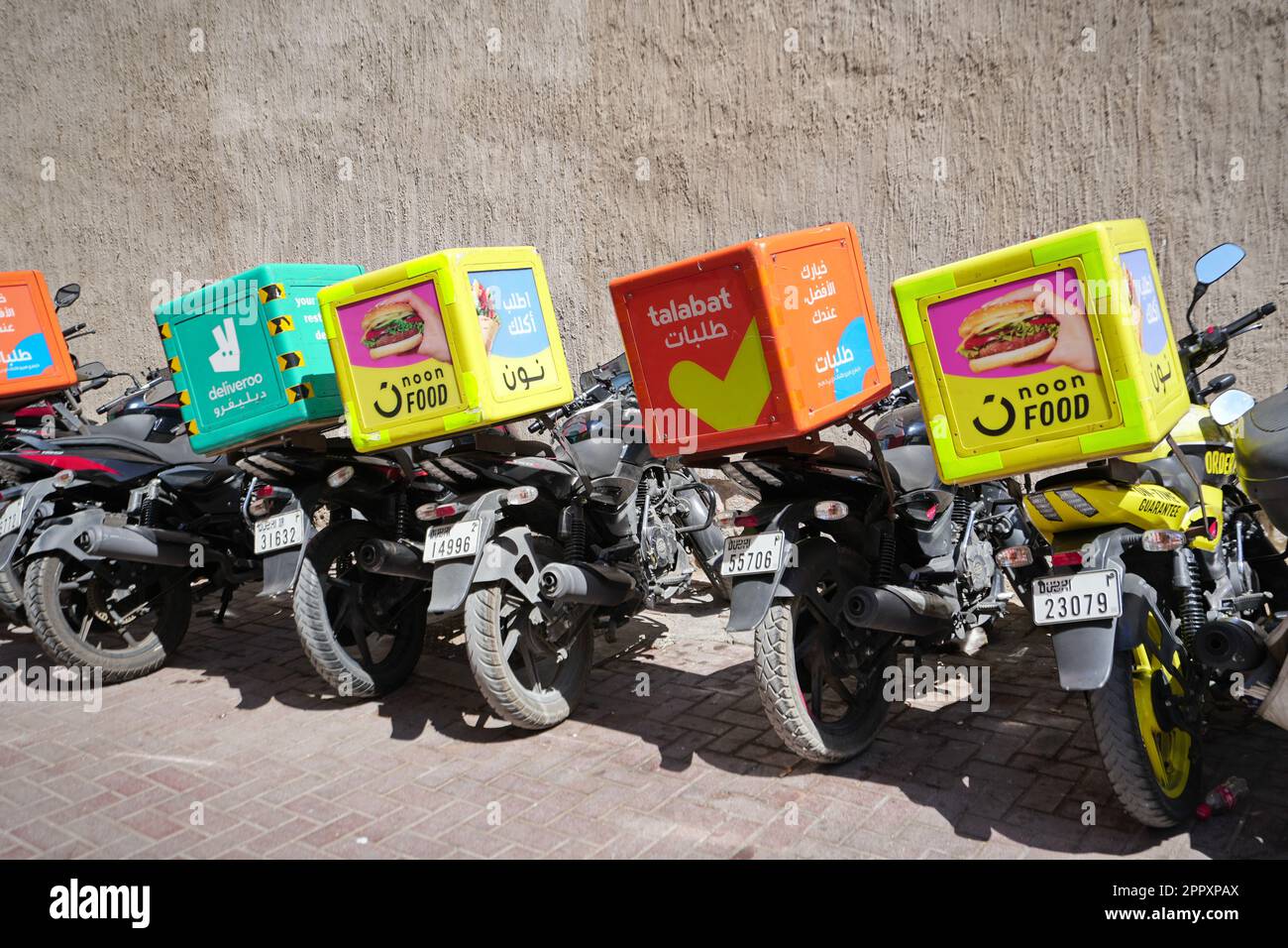 Motorrad-Food-Lieferung auf dem Parkplatz. Dubai, Vereinigte Arabische Emirate - April 2023 Stockfoto