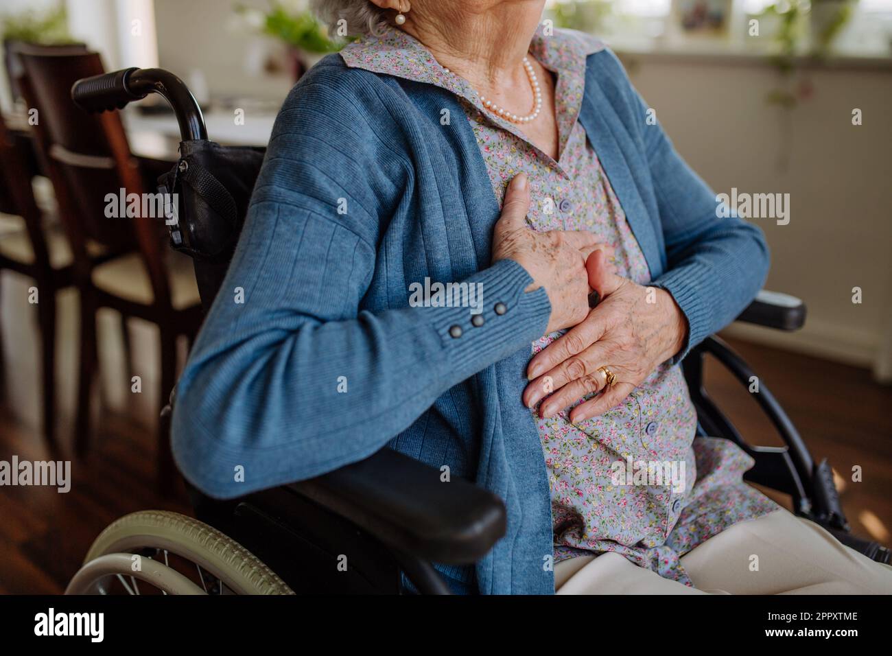 Nahaufnahme einer älteren Frau im Rollstuhl mit Schmerzen in der Brust. Stockfoto