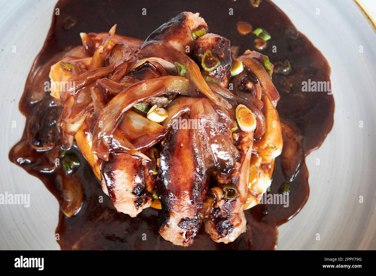 In einem Restaurantbezirk donegal republic of ireland werden lokal hergestellte Wurstwaren aus Schweinefleisch mit Zwiebelsoße serviert Stockfoto