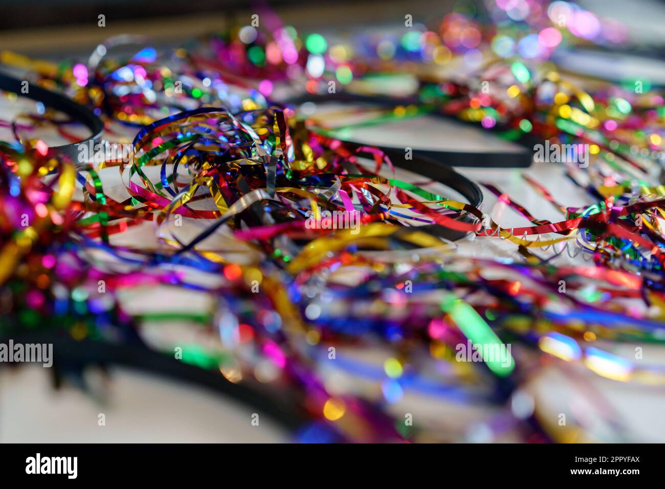 Festliche Stirnbänder mit Lametta zur Geburtstags- oder Partyvorbereitung. Farbenfrohe Stirnbänder bereit für Party. Festliche Bügel mit Lametta auf einem Tisch, perfekt für Geburtstage und besondere Anlässe. Stockfoto
