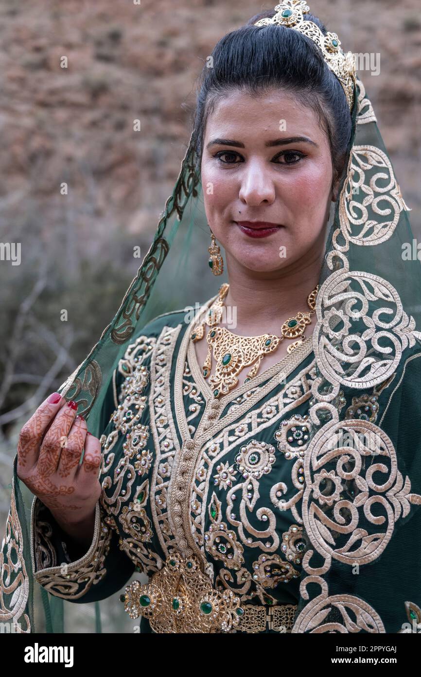 Porträt einer Braut in einem wunderschönen Kleid mit goldenen Motiven. Stockfoto