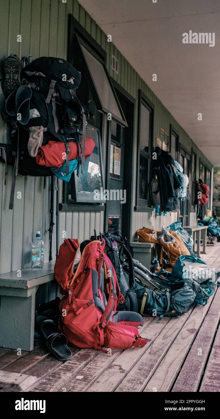 Stiefel und Rucksäcke wurden außerhalb der Hütte gelassen, um den Wanderer auf Stewart Island, Neuseeland, eine Pause zu bieten Stockfoto