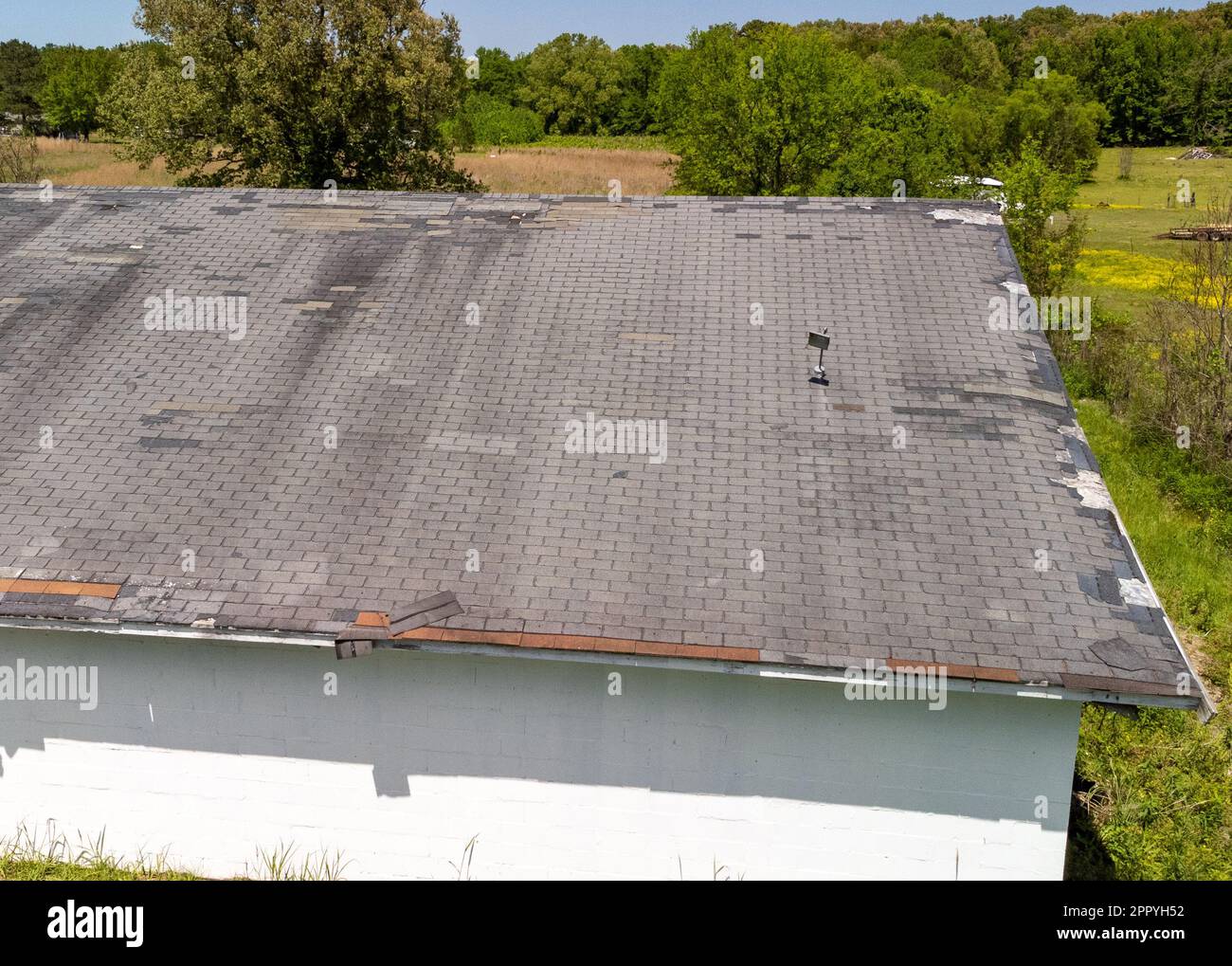 Auf dem Dach fehlen aufgrund von Alter, Wetter und Sturmschäden Schindeln Stockfoto