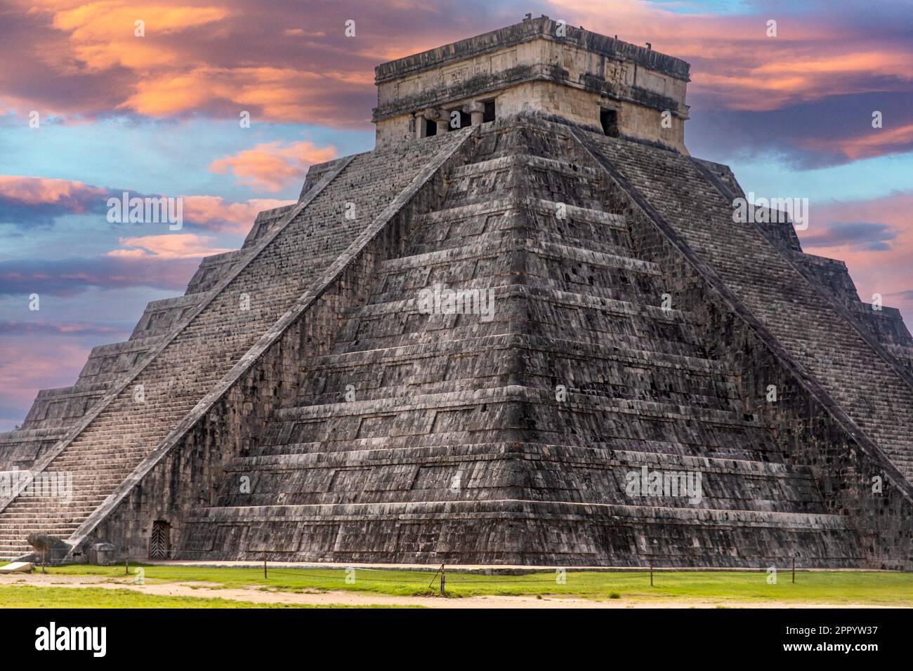 Das Schloss und der Tempel von Chichen Itza, bekannt als die berühmte Maya-Pyramide von Mexiko unter einem apokalyptischen orangefarbenen Himmel, gehört zur Maya-Kultur und Stockfoto