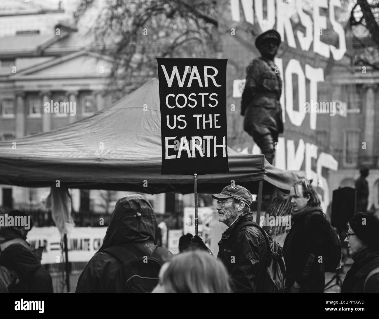 Schwarzweißfoto eines Anti-Kriegs-Demonstranten, der während des Aussterbens des Rebellion Wochenendes der Proteste am 2023. April ein Anti-Kriegs-Plakat in Whitehall hielt. Stockfoto
