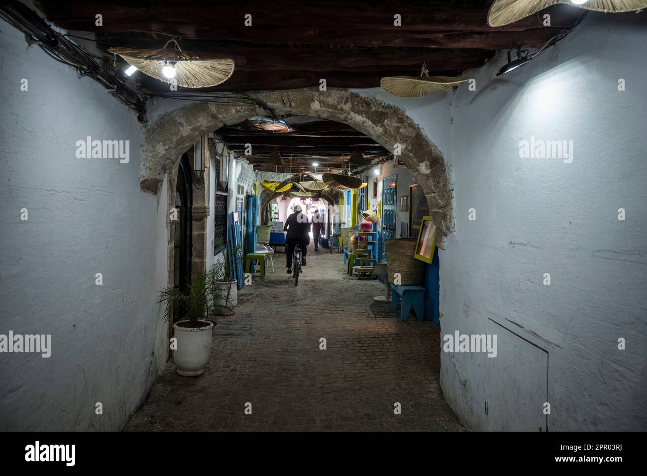 Silhouetten von Menschen, die sich durch eine Gasse in der Medina von Essaouira bewegen. Stockfoto