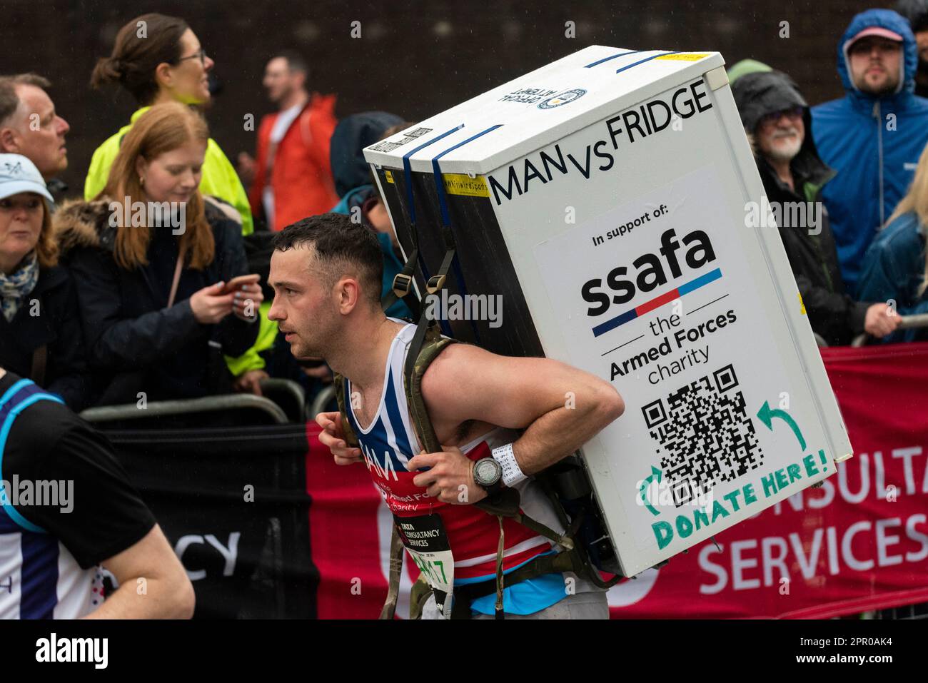 Sam Hammond trug einen Kühlschrank, während er beim TCS London Marathon 2023 durch Tower Hill, London, Großbritannien, teilnahm. SSAFA-Wohltätigkeitskandidat Stockfoto