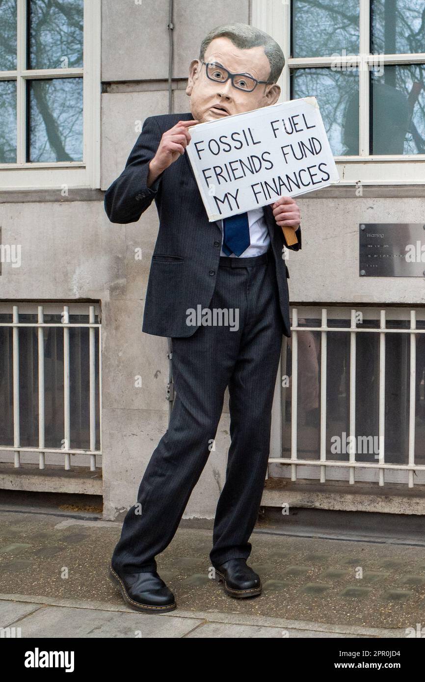 Demonstranten tragen eine Politikermaske und halten Plakat über Fossil Fuels beim Aussterben Rebellion Protest Weekend in der Nähe von Westminster, London, April 2023 Stockfoto