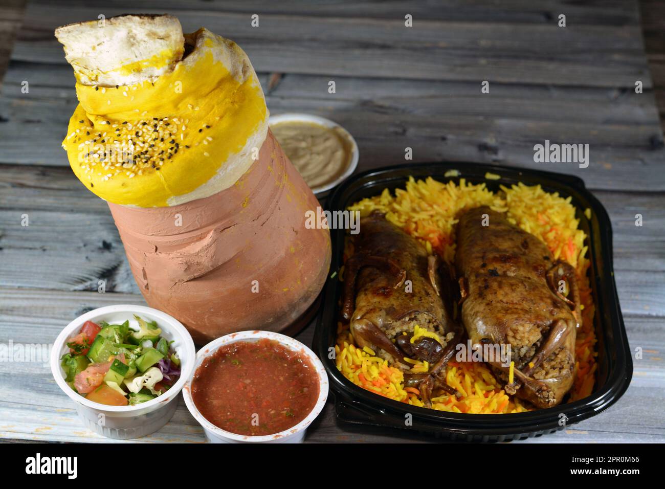 Hintergrund der ägyptischen Hamam-Tauben Mahshi gefüllte Squab mit Reis und Ein Töpfertopf mit Teig, Sesam und Lammschaft ist darin mit Bas bedeckt Stockfoto