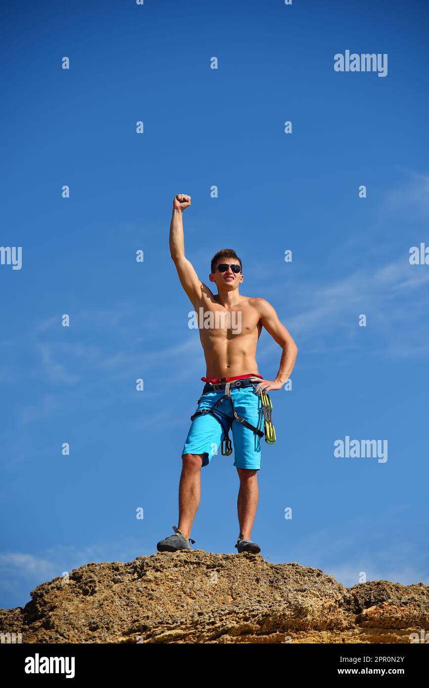 Männlicher Kletterer Hebt Hand Auf Dem Gipfel Des Berges. Erfolgskonzept Stockfoto