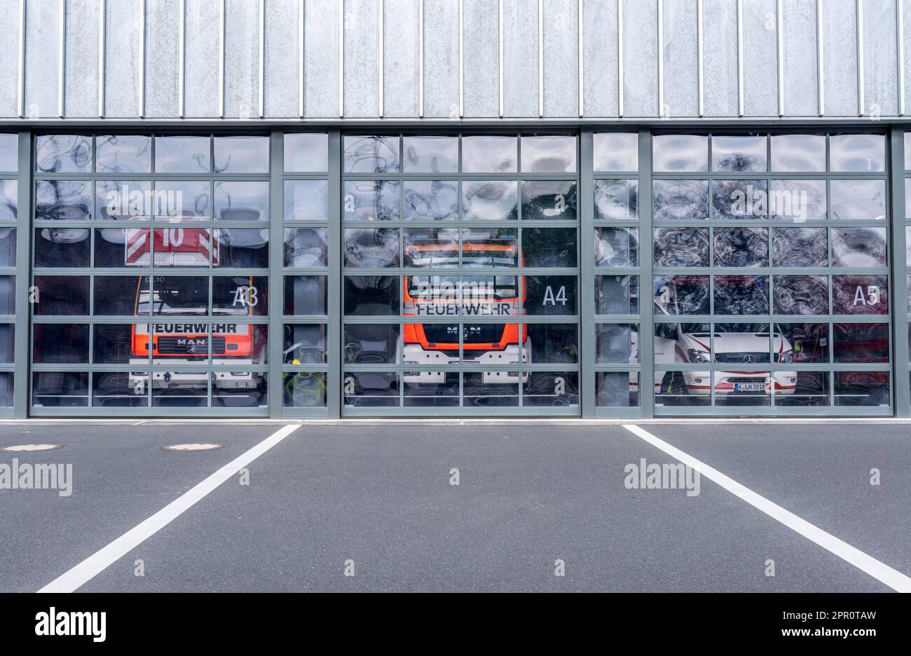 Feuerwehr, Feuerwehr, moderne Station, Glastore, in der Fahrzeughalle stehende Einsatzfahrzeuge, Köln, NRW, Deutschland, Stockfoto