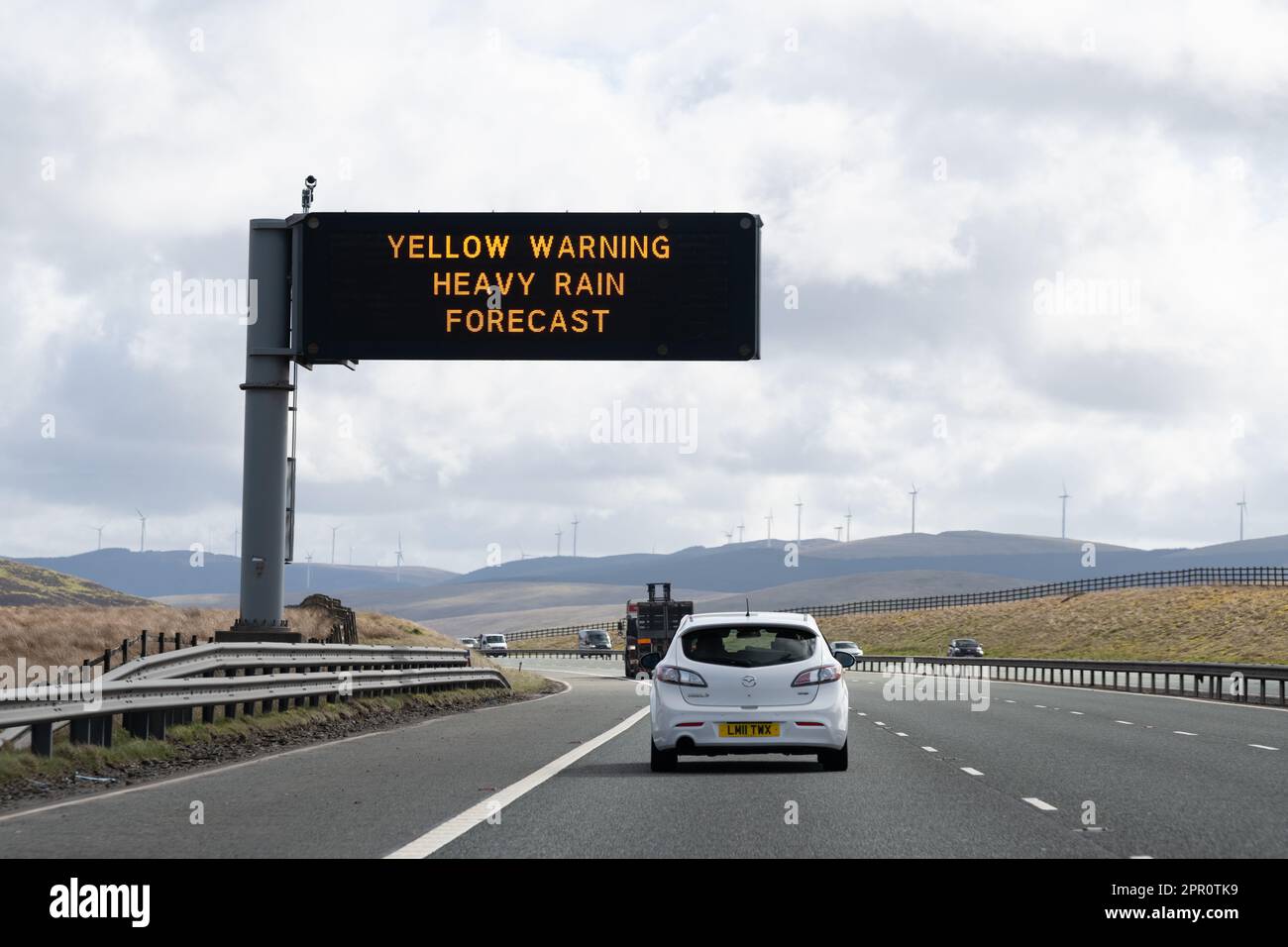 Gelbes Warnschild für schwere Regenvorhersage auf der Autobahn für Großbritannien Stockfoto