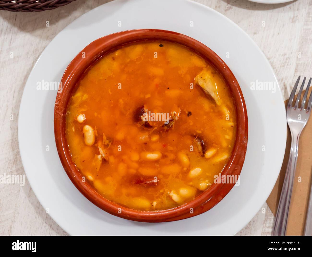 Fabada asturiana serviert in braunen Teller Stockfoto