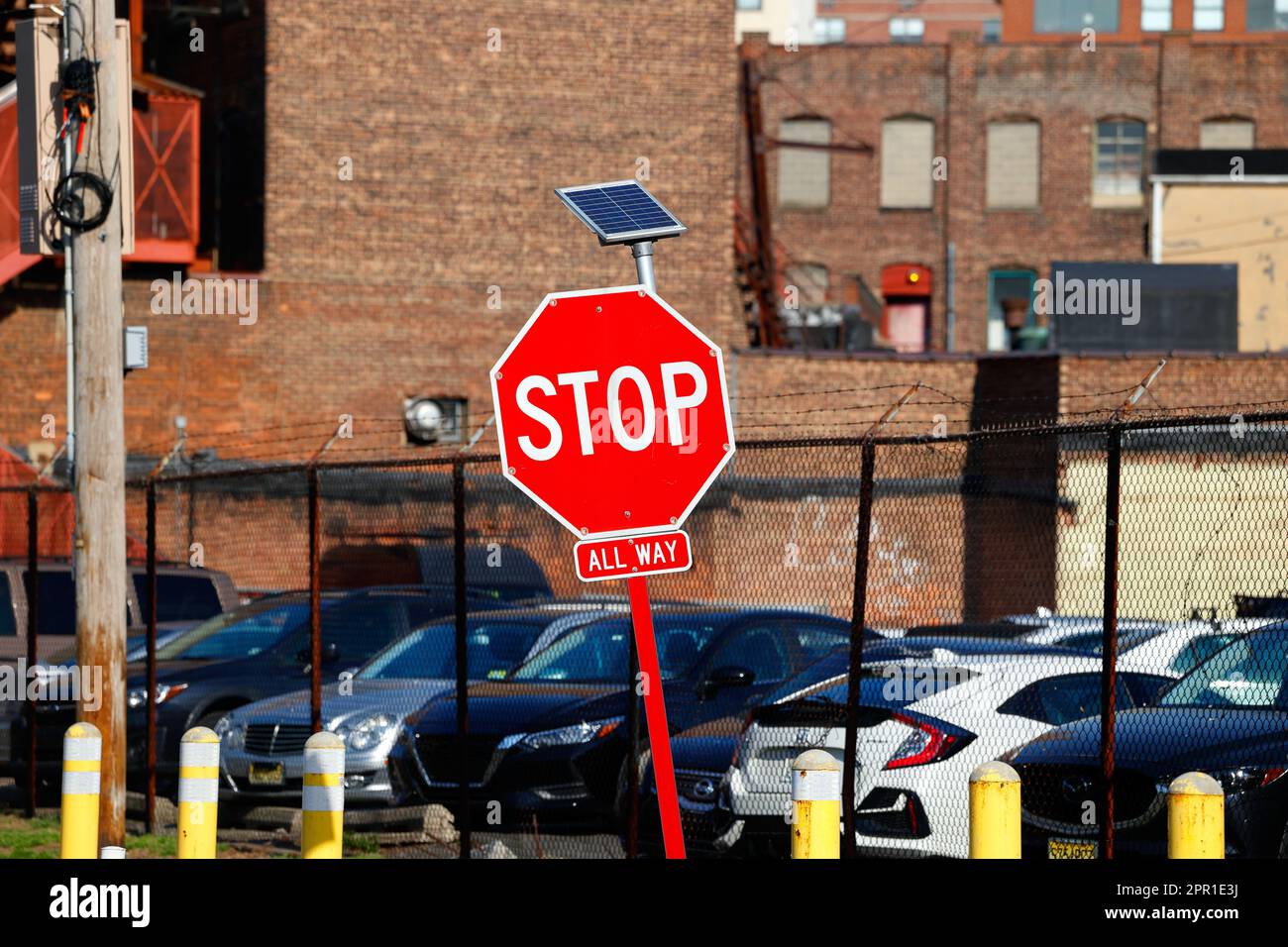 Ein solarbetriebenes blinkendes LED-Stoppschild. Diese solarbetriebenen Schilder werden während der Abendstunden beleuchtet, um den Fahrer auf das Schild aufmerksam zu machen. Stockfoto