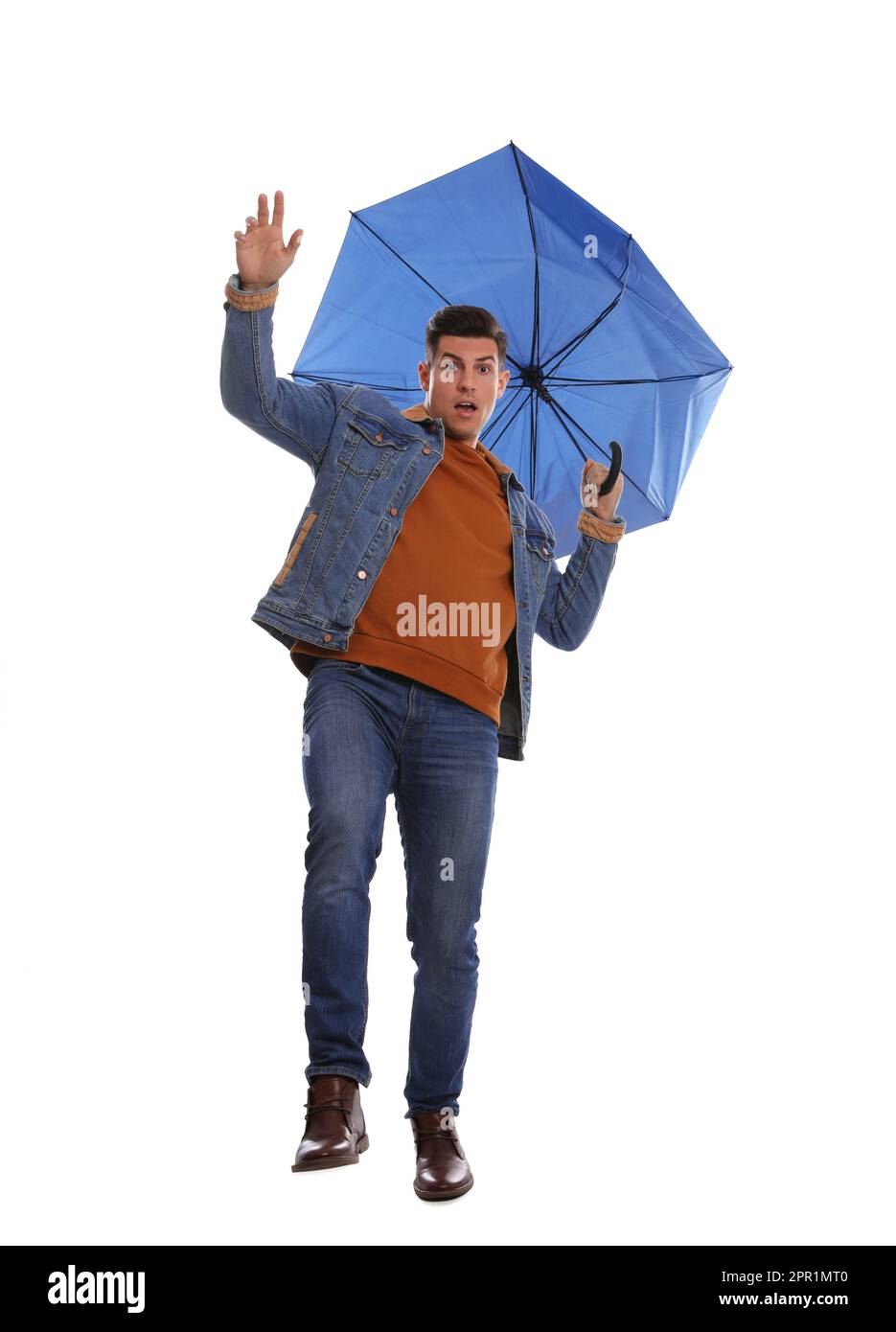 Emotionaler Mann mit Regenschirm, der von Windböen auf weißem Hintergrund gefangen wurde Stockfoto