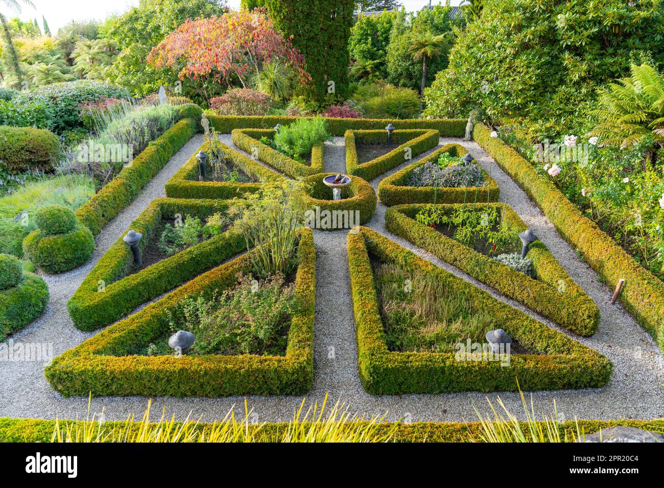 Landschaftsdesign gepflegte Box Hecke Garten dreieckige Anordnung rund um Kräutergärten. Stockfoto