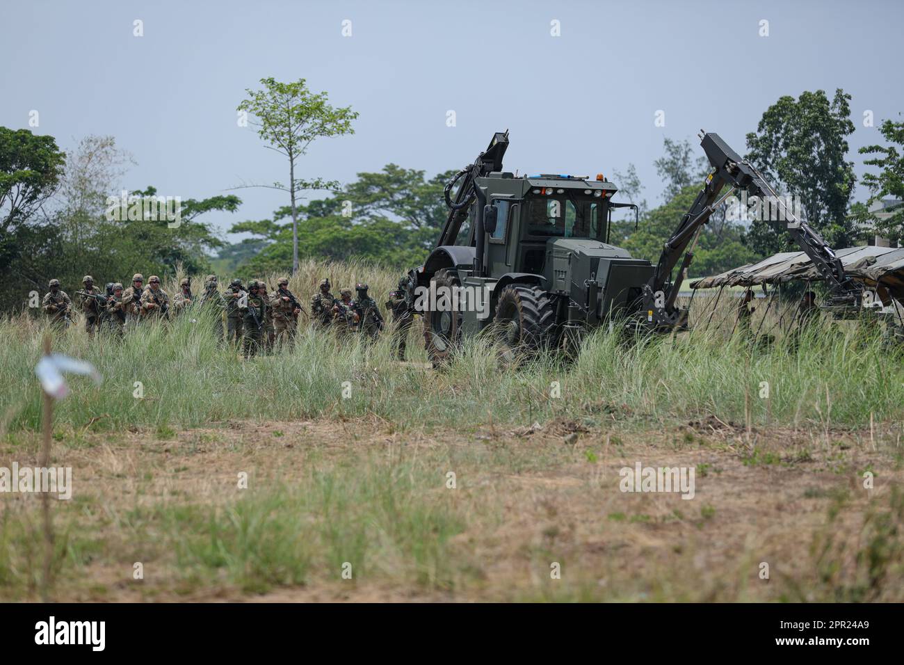 US-Soldaten und philippinische Soldaten patrouillieren hinter einem am Fahrzeug montierten Minendetektor während eines Abbruchs auf Fort Magsaysay, Philippinen, als Teil von Balikatan 23, am 21. April 2023. Die Mission umfasste eine Infiltration in das Ziel, die Beseitigung von Hindernissen mit Sprengstoffen, Maßnahmen zum Ziel, vor-Ort-Medizin für simulierte Verletzte und taktische Exfiltration aus dem Ziel. Balikatan 23 ist die 38. Wiederholung der jährlichen bilateralen Übung zwischen den Streitkräften der Philippinen und dem US-Militär. Die Übung umfasst eine 3-wöchige Schulung mit Schwerpunkt auf amphibischen Operationen, Stockfoto