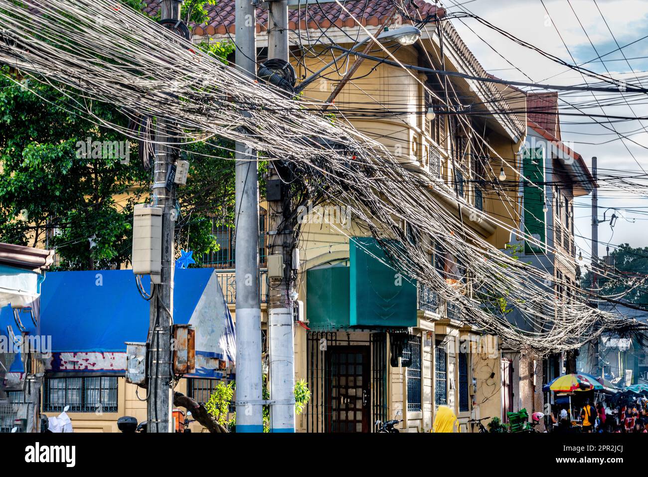 Viele Hunderte von Stromleitungen, die über der Straße hängen, die Häuser und Unternehmen mit Strom versorgen, rund um Intramuros, Stockfoto